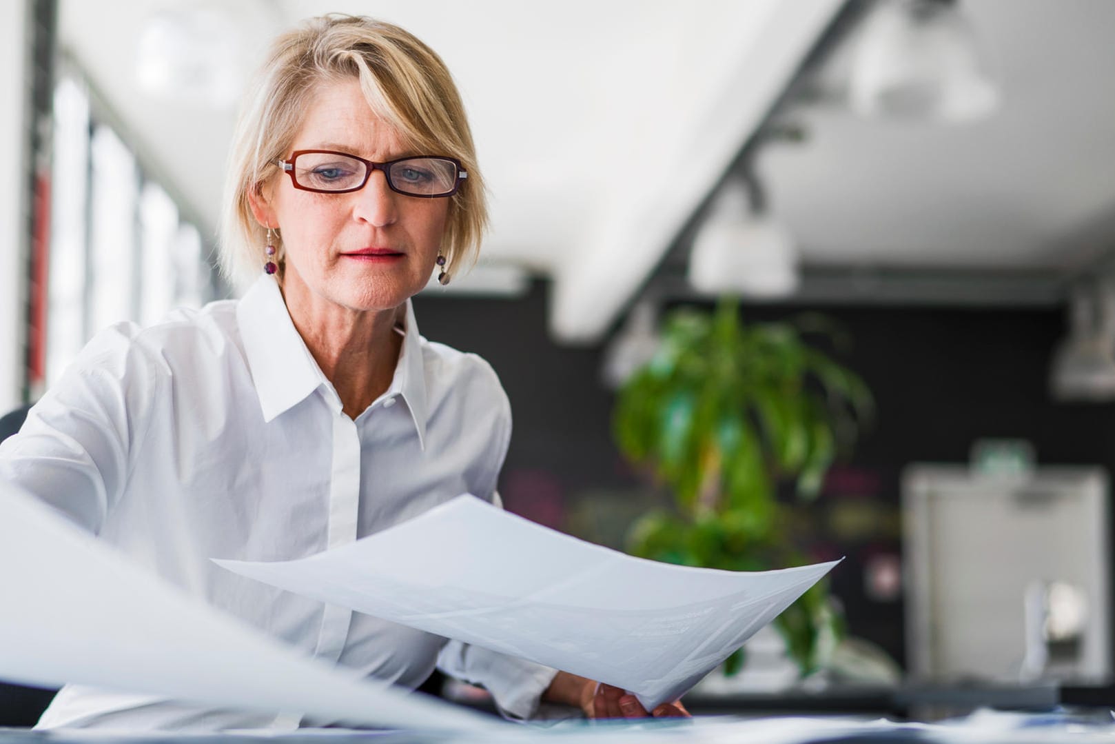 Eine Frau sichtet Unterlagen (Symbolbild): Wer mit dem Finanzamt kommunizieren will, benötigt in der Regel seine Steuernummer.