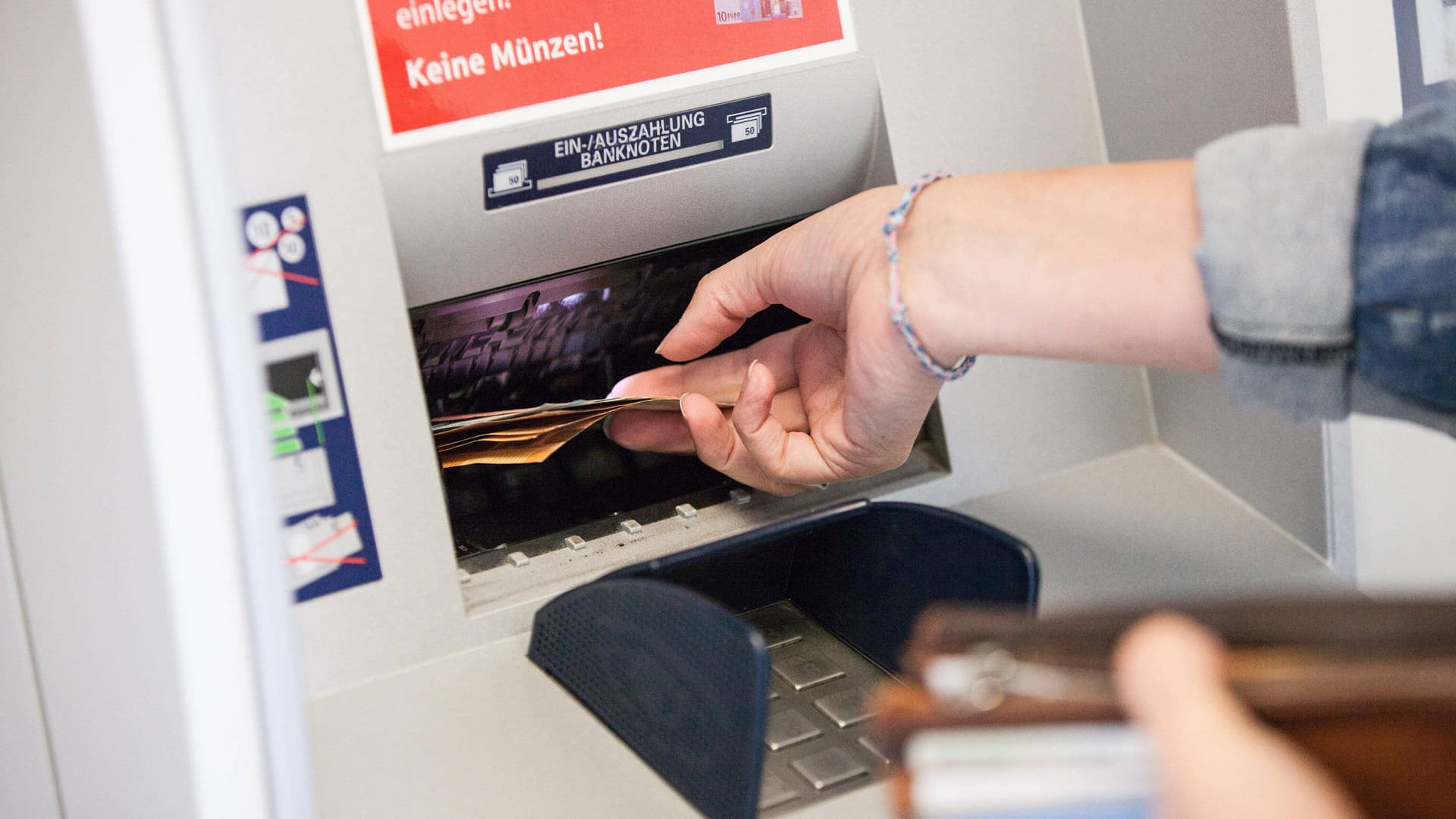 Eine Frau entnimmt Bargeld aus einem Bankautomaten: Die Gewerkschaft Verdi hat Geldboten zum Streik aufgerufen.