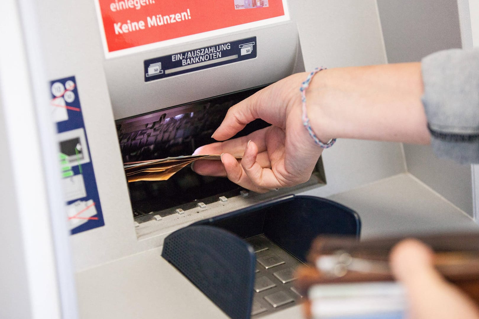 Eine Frau entnimmt Bargeld aus einem Bankautomaten: Die Gewerkschaft Verdi hat Geldboten zum Streik aufgerufen.