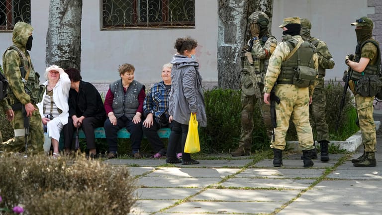 Russische Soldaten und eine Gruppe von Frauen im besetzten Cherson: Nicht einmal Bier soll es noch geben.