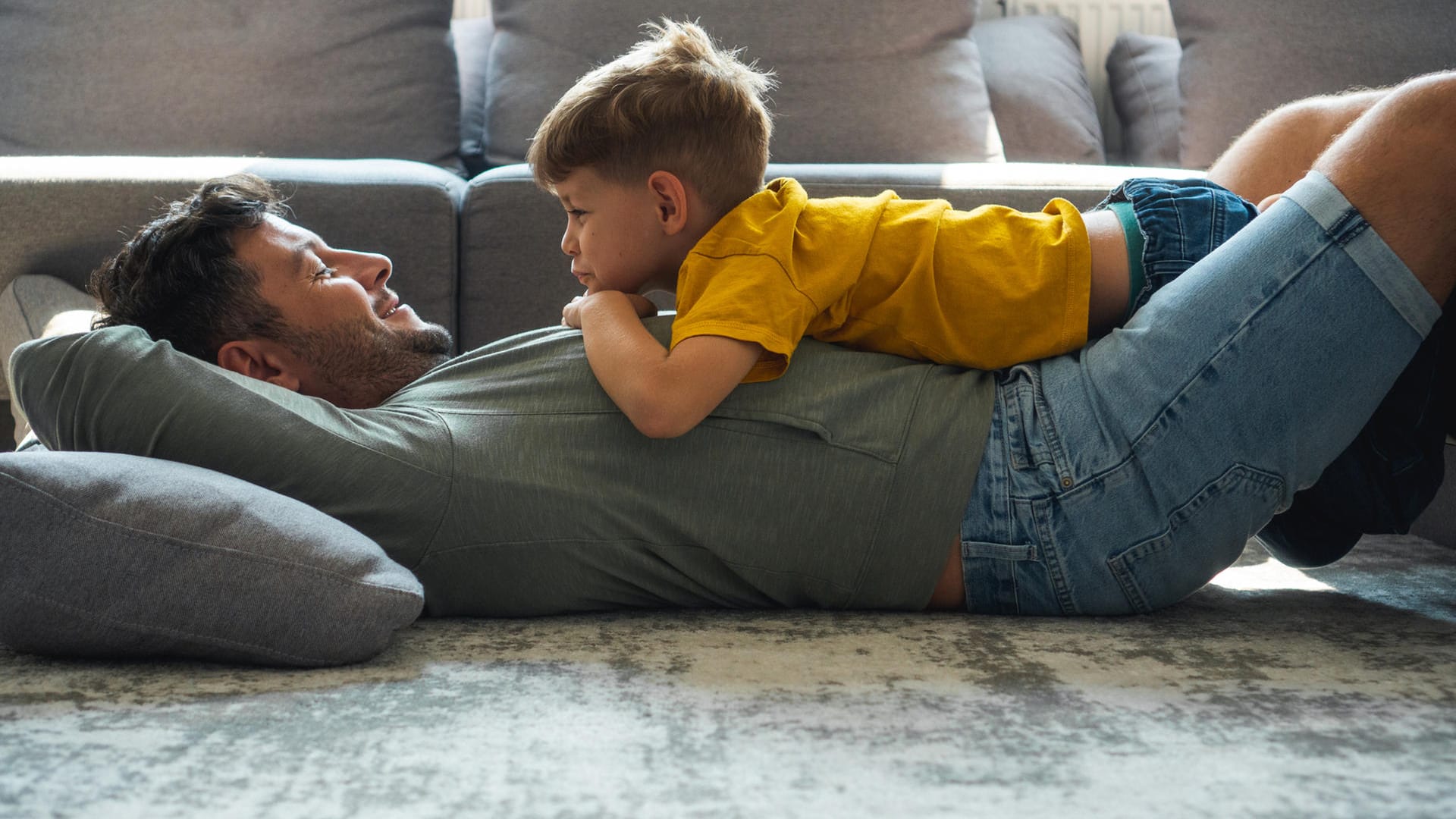 Vater und Sohn spielen im Wohnzimmer (Symbolbild): Alleinerziehende mindern mit dem Entlastungsbetrag ihre Steuerlast.