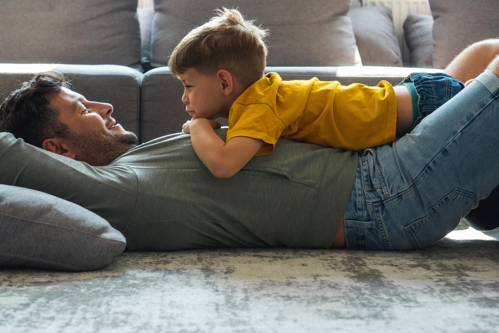 Vater und Sohn spielen im Wohnzimmer (Symbolbild): Alleinerziehende mindern mit dem Entlastungsbetrag ihre Steuerlast.