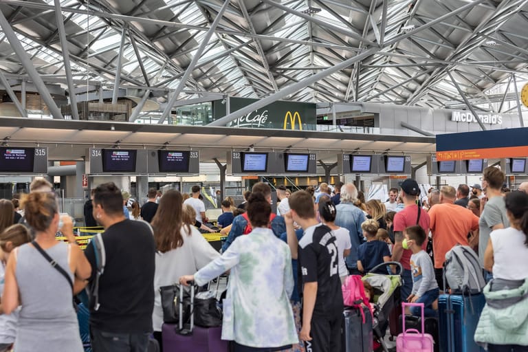 Ein überfüllter Check-in-Schalter am Flughafen Köln-Bonn: Im Sommer warteten Reisende mehrere Stunden auf ihren Flug – oder strandeten sogar.