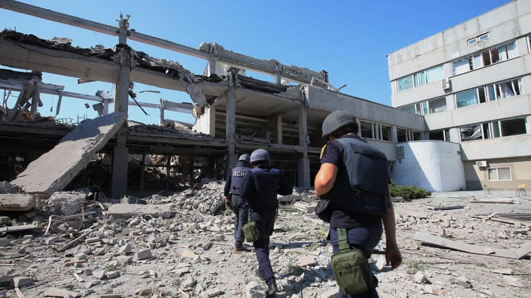 Rettungskräfte untersuchen einen Teil der durch einen Raketenangriff zerstörten Pädagogischen Universität in Charkiw.