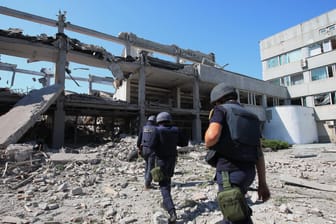 Rettungskräfte untersuchen einen Teil der durch einen Raketenangriff zerstörten Pädagogischen Universität in Charkiw.