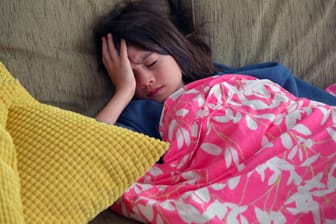 Junges Mädchen greift sich an den Kopf. Wie auch bei Erwachsenen sind Migräne und Spannungskopfschmerz die häufigsten primären Kopfschmerzerkrankungen bei Kindern.