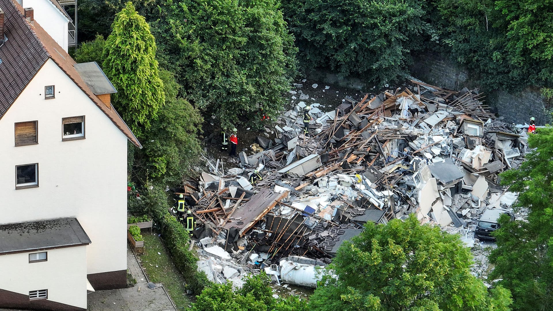 Feuerwehrleute untersuchen die Trümmer in Hemer: Noch immer sind Menschen darunter begraben.