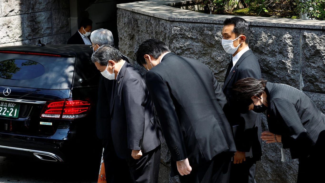 Japanische Abgeordnete beten, während der Leichnam von Shinzo Abe in sein Wohnaus in Tokio gebacht wird.