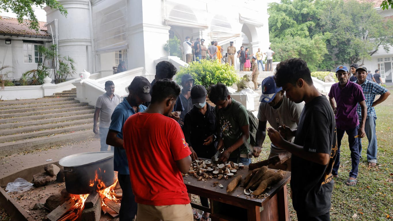 Demonstranten kochen im Garten der Residenz des Premierministers.