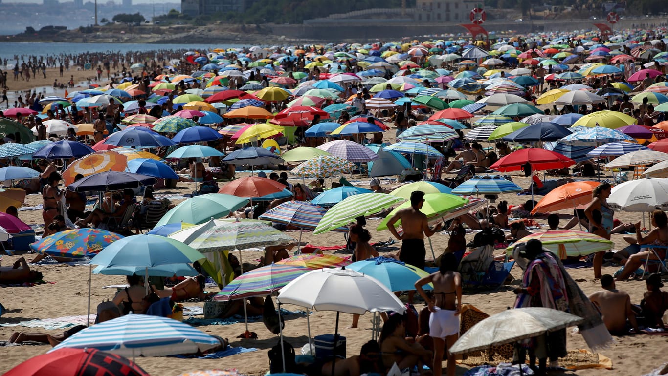 Bei der Hitze in Portugal halten viele Menschen sich am Strand auf.