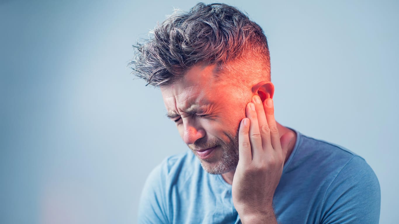 Mann mit Ohrenschmerzen: Wenn die Ohren über einen längeren Zeitraum Lärm ausgesetzt sind, kann dies dem Hörvermögen schaden. Dabei spielt die Lautstärke keine besondere Rolle.