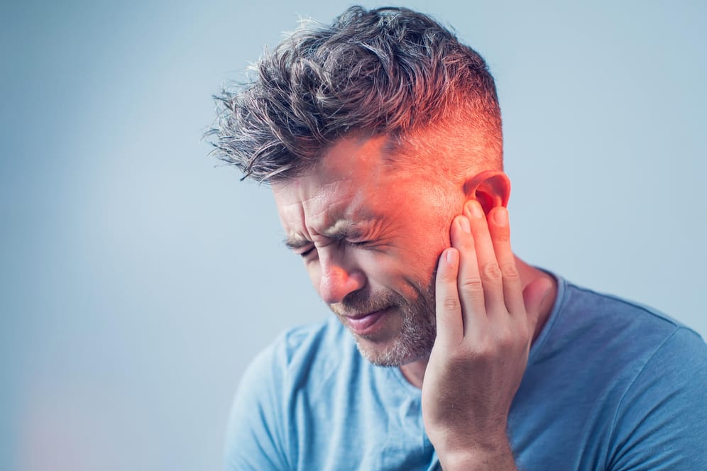 Mann mit Ohrenschmerzen: Wenn die Ohren über einen längeren Zeitraum Lärm ausgesetzt sind, kann dies dem Hörvermögen schaden. Dabei spielt die Lautstärke keine besondere Rolle.