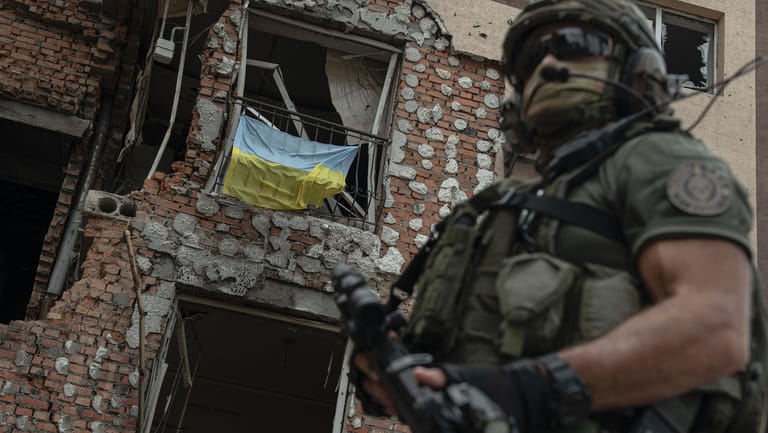 Ukraine, Irpin: Ein ukrainischer Soldat steht vor einem zerstörten Gebäude.