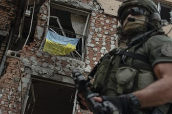 Ukraine, Irpin: Ein ukrainischer Soldat steht vor einem zerstörten Gebäude.