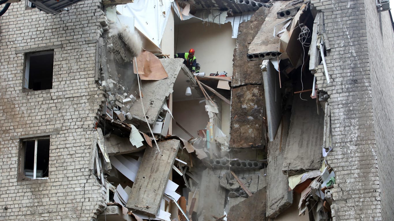 Rettungskräfte beseitigen die Trümmer eines zerstörten Gebäudes in Charkiw.