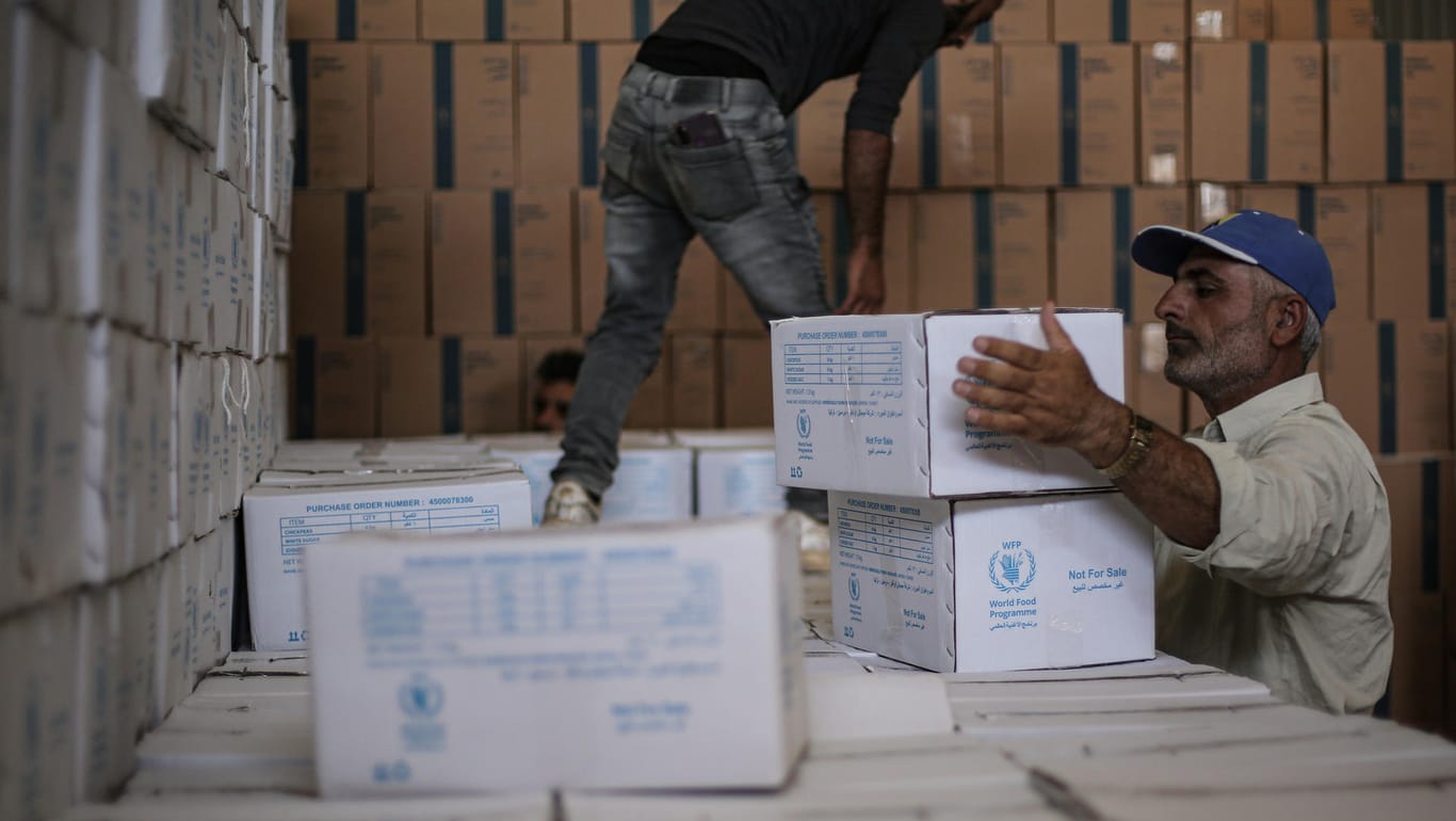 Bab Al-Hawa: Syrer lagern humanitäre Hilfsgüter des Welternährungsprogramms.