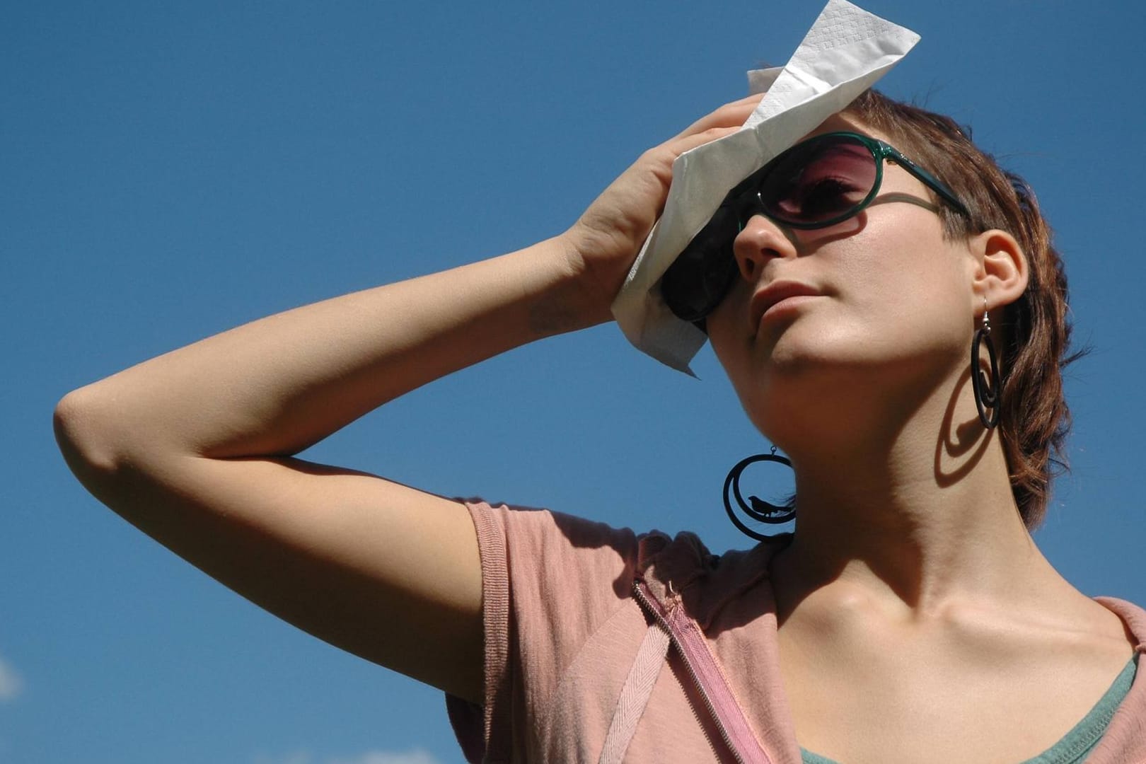 Frau steht in der prallen Sonne (Symbolbild): Deutschland muss sich auf eine Hitzewelle einstellen.