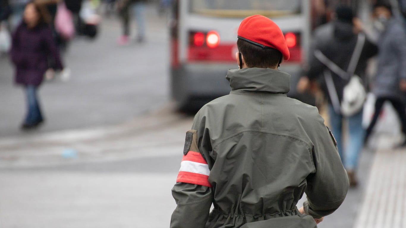 Ein Soldat des österreichischen Bundesheeres läuft uniformiert durch eine Fußgängerzone.