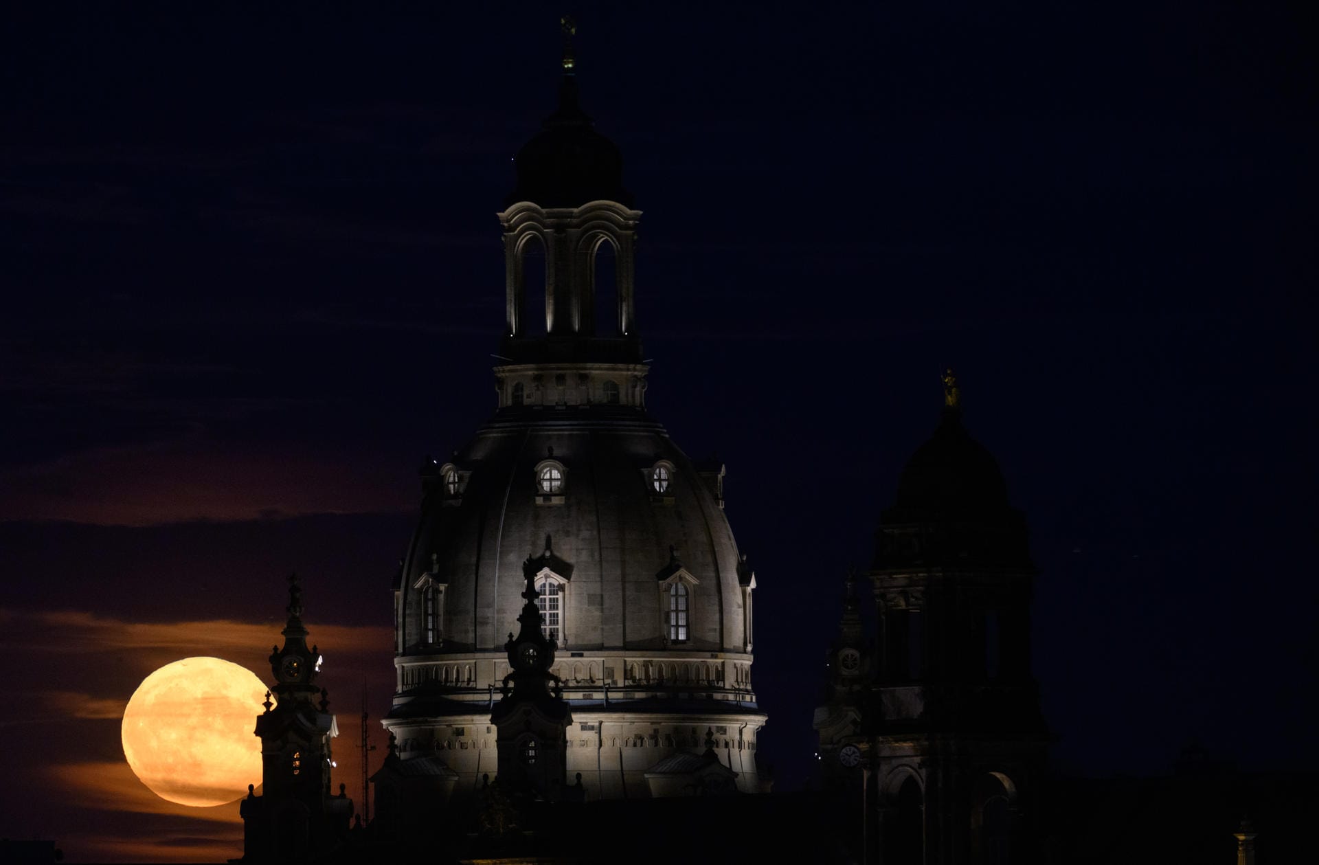 Der Vollmond sieht hinter der Frauenkirche in Dresden besonders imposant aus.