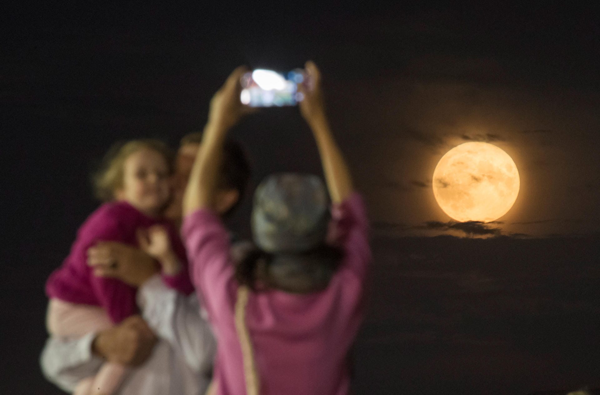 Menschen fotografieren den Mond in Moskau, Russland.