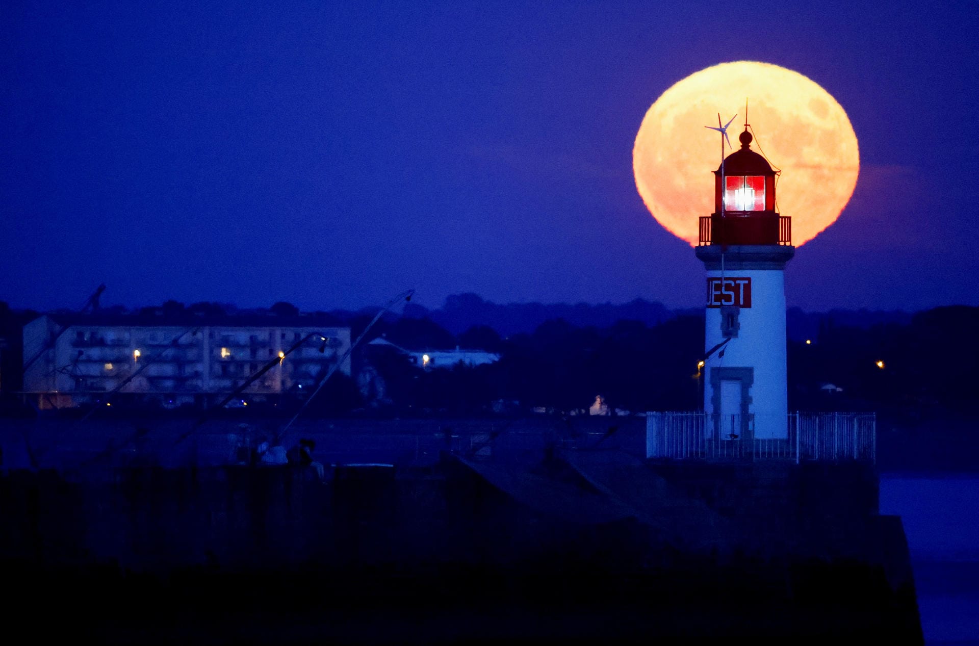 Der Supermond steht hinter einem Leuchtturm in Saint-Nazaire, Frankreich.