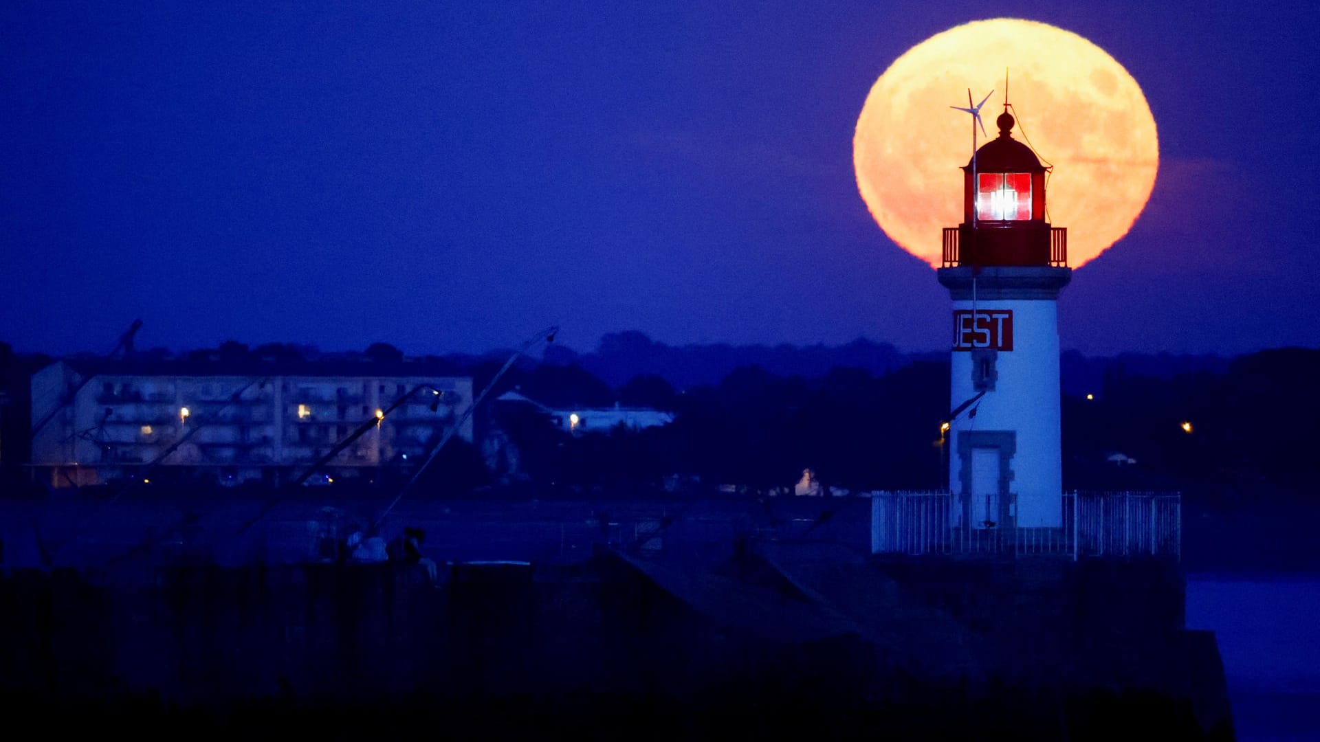 Der Supermond steht hinter einem Leuchtturm in Saint-Nazaire, Frankreich.