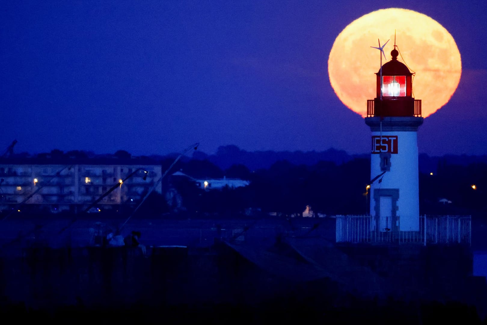 Der Supermond steht hinter einem Leuchtturm in Saint-Nazaire, Frankreich. Der Supermond steht hinter einem Leuchtturm in Saint-Nazaire, Frankreich.