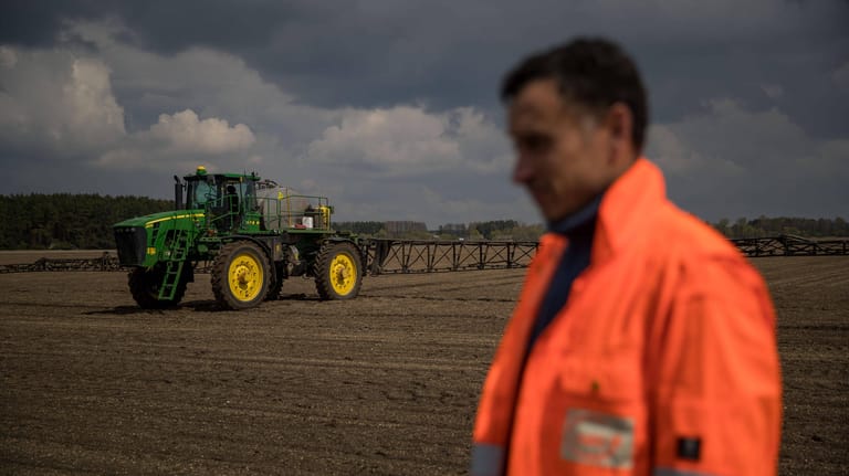A farmer and a tractor are seen at a crop field in the surroundings of Kyiv, Ukraine, on 27 April 2022. Seven out of ten