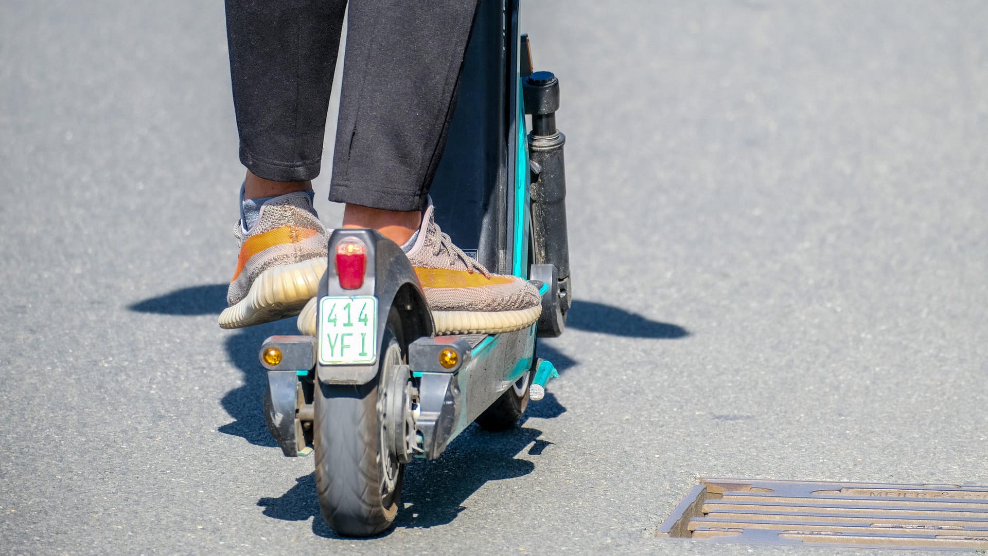 Ein Mann fährt mit einem E-Roller auf der Straße.