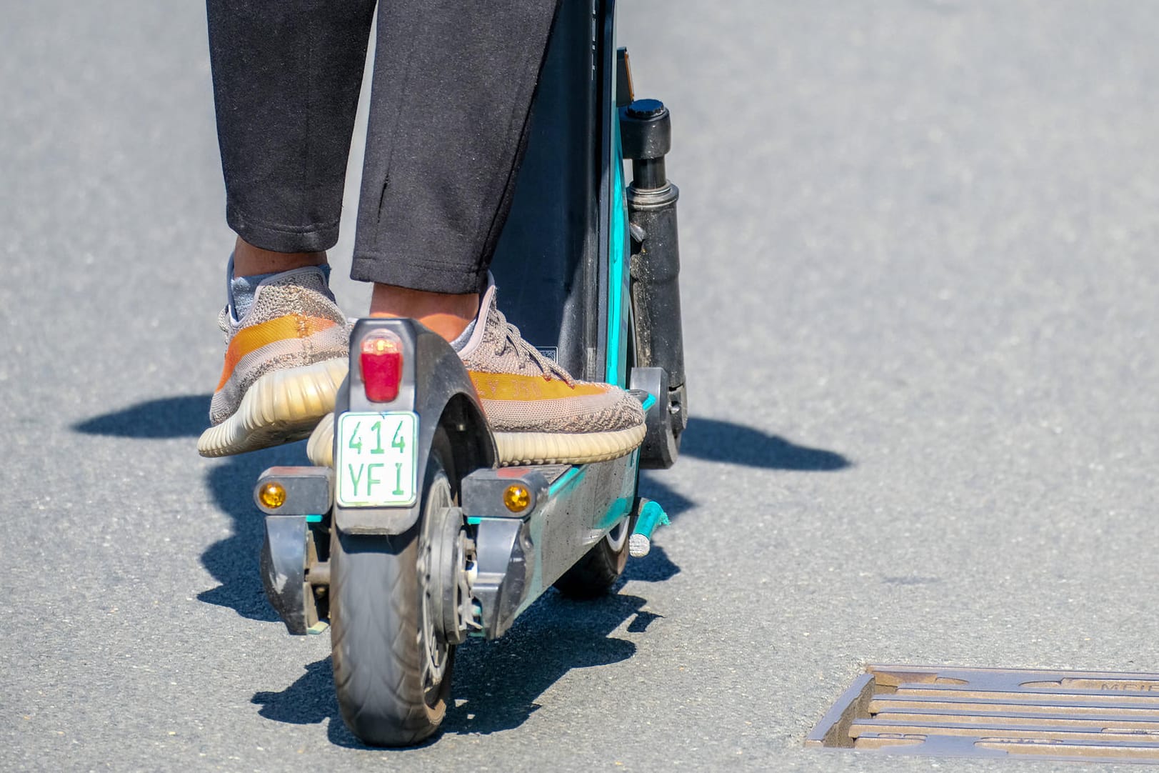 Ein Mann fährt mit einem E-Roller auf der Straße.