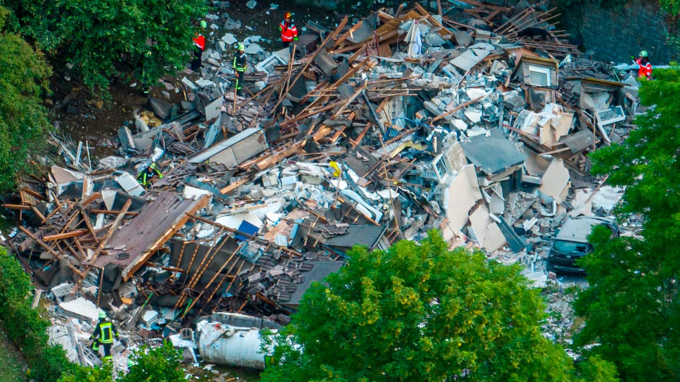 Feuerwehrleute untersuchen die Trümmer eines eingestürzten Hauses. Die Unglücksursache ist weiter unklar.