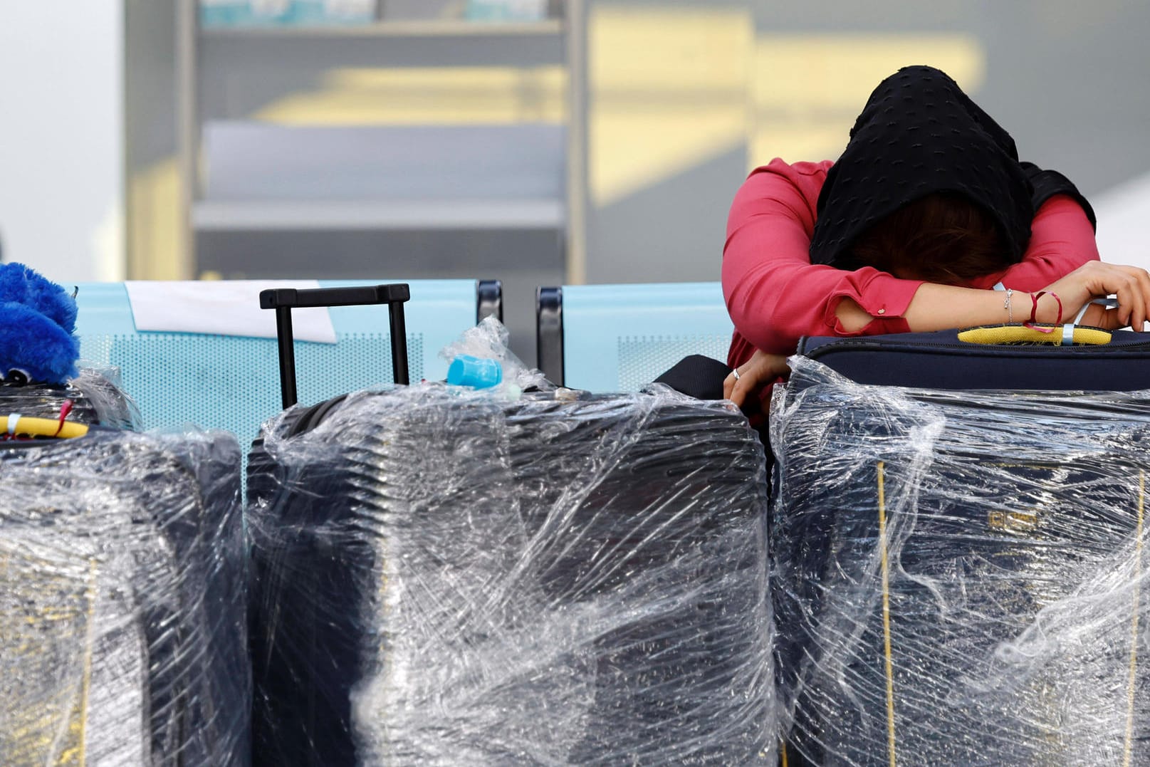 Eine erschöpfte Reisende am Flughafen Köln-Bonn. Passagiere müssen dort mehrere Stunden auf Check-In oder vor Sicherheitskontrollen warten.