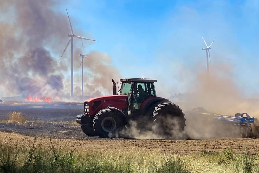 Hitze in Brandenburg: ei der Ernte ist aus bisher unbekannter Ursache ein Brand ausgebrochen und hat mehrere Hektar Getreide vernichtet.