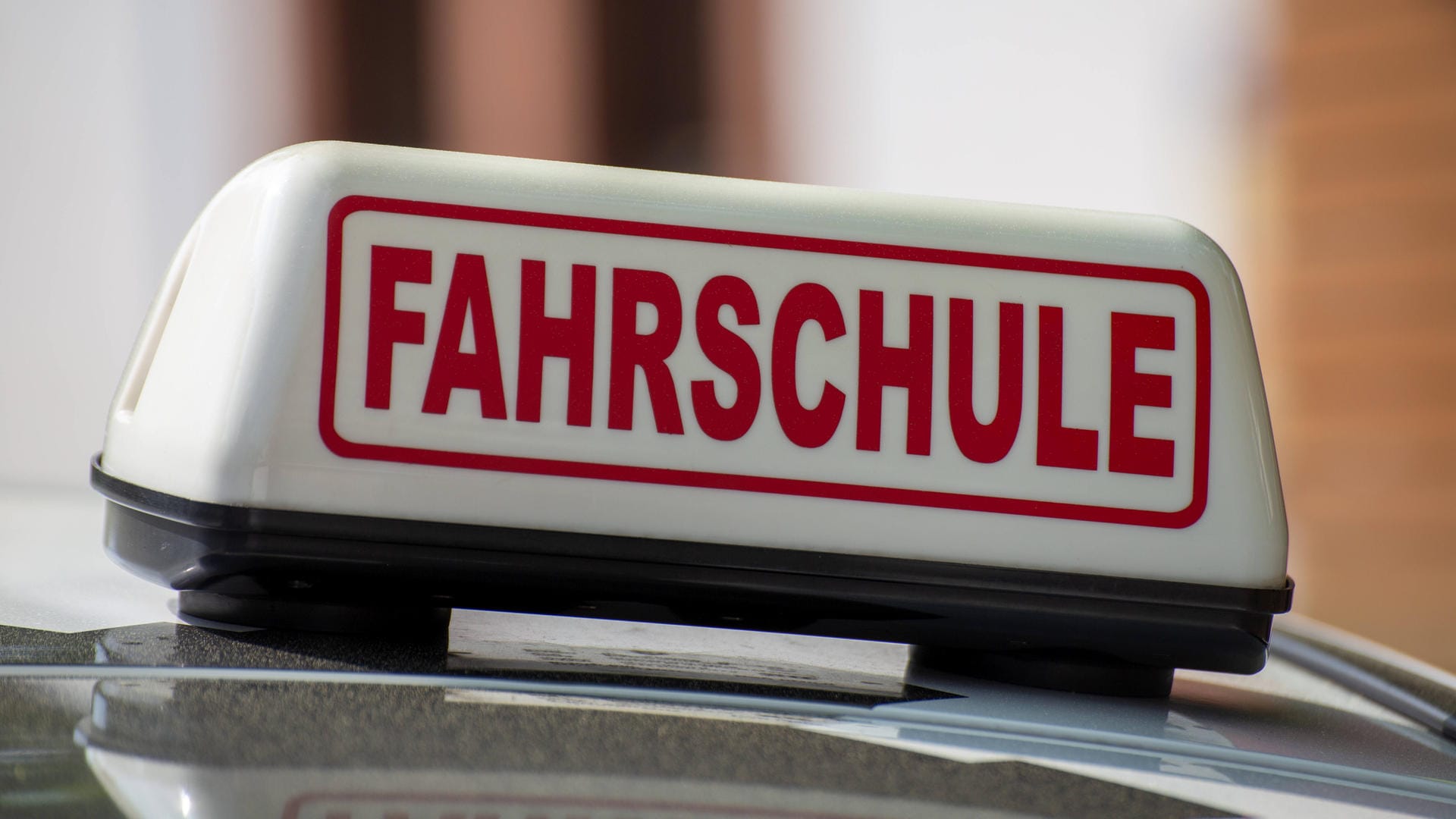 Ein Fahrschule-Schild auf einem Auto: Es ist nicht verkehrt, sein Wissen über den Straßenverkehr aufzufrischen.