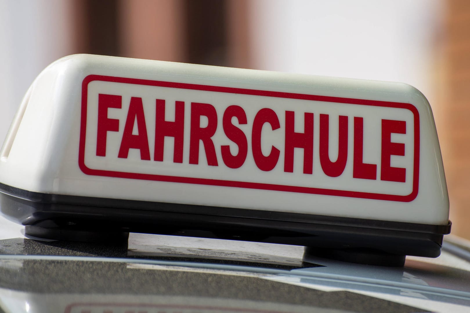 Ein Fahrschule-Schild auf einem Auto: Es ist nicht verkehrt, sein Wissen über den Straßenverkehr aufzufrischen.