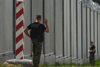 Polnische Grenzschützer an der Mauer zu Belarus (Archiv): Schleuser sollen Migranten über Belarus in die EU gebracht haben.