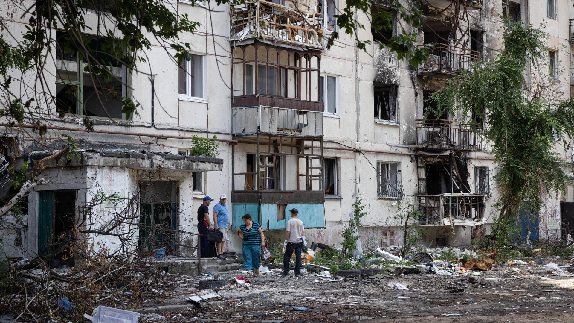 Menschen vor einem beschädigten Wohnhaus in Sjewjerodonezk: Die Stadt in der Region Luhansk befindet sich unter russischer Kontrolle.