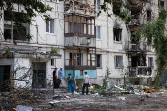 Menschen vor einem beschädigten Wohnhaus in Sjewjerodonezk: Die Stadt in der Region Luhansk befindet sich unter russischer Kontrolle.