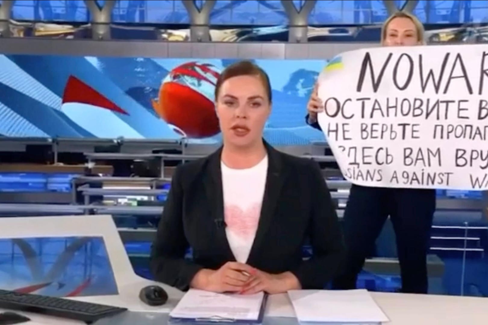 Marina Owsjannikowa (Hintergrund) im russischen TV-Sender "Perwy Kanal": Nach ihrer Protestaktion gegen den Ukraine-Krieg will die 43-Jährige nun für den den deutschen Nachrichtsender "Welt" als freie Korrespondentin arbeiten.