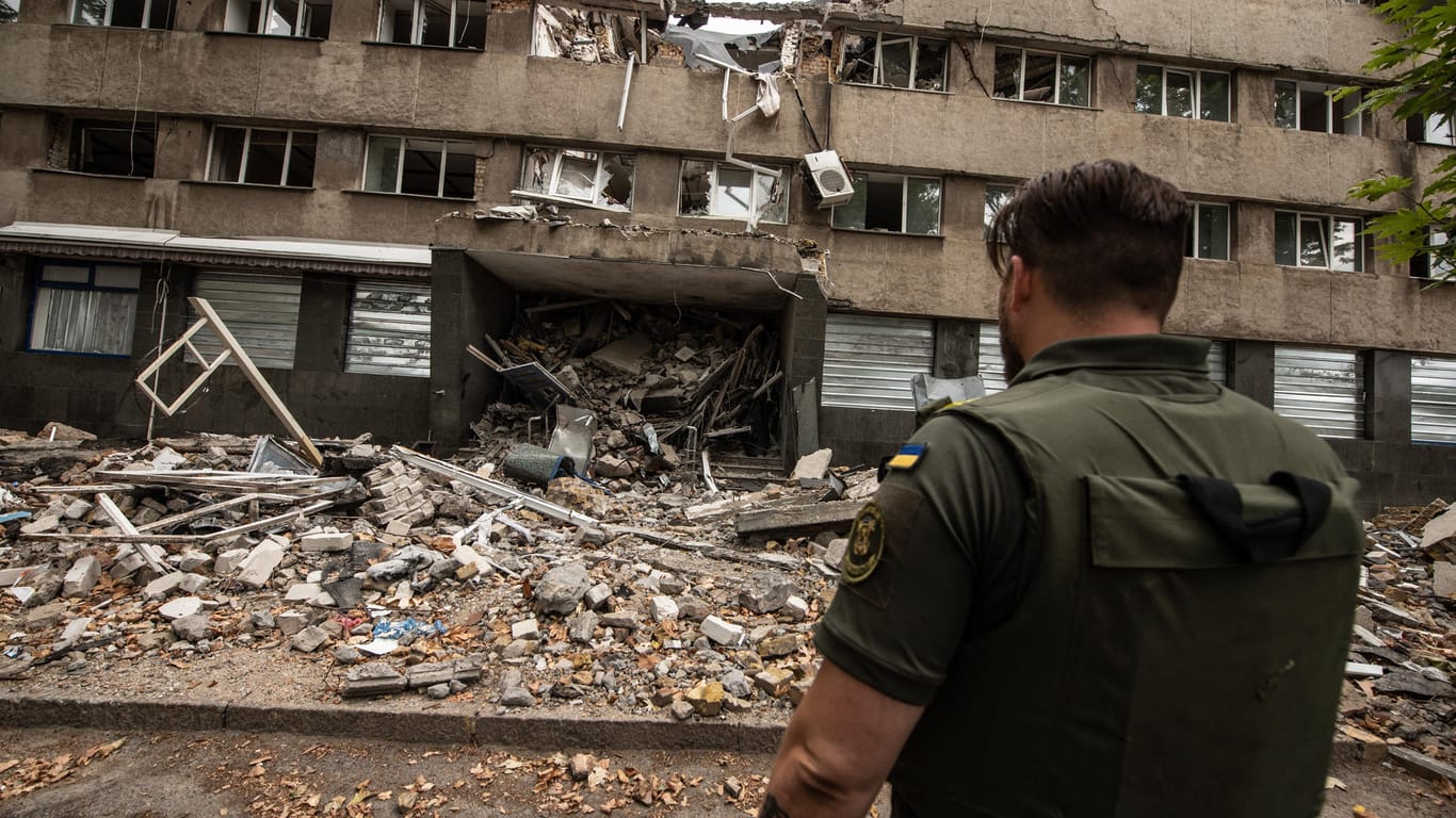 Ein ukrainischer Soldat steht vor einem zerstörten Haus in Mykolajiw: Seit 145 Tagen herrscht in der Ukraine der Krieg.