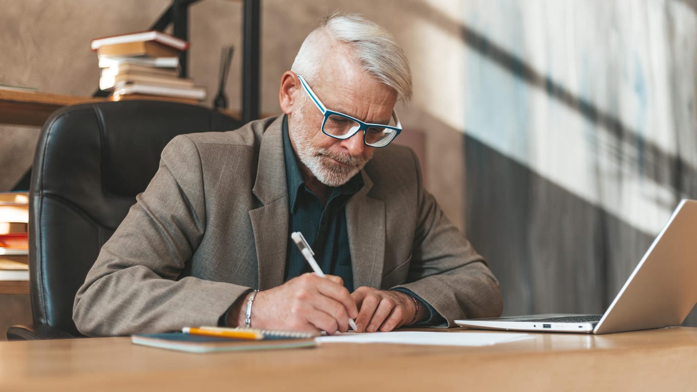 Älterer Mann unterzeichnet ein Dokument (Symbolbild): Schenkungen haben gegenüber Erbschaften einen steuerlichen Vorteil: die 10-Jahresfrist.