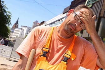 Ein Bauarbeiter schwitzt bei über 30 Grad in Hannover auf einer Baustelle: Verdi fordert längere Pausen und früheren Feierabend.