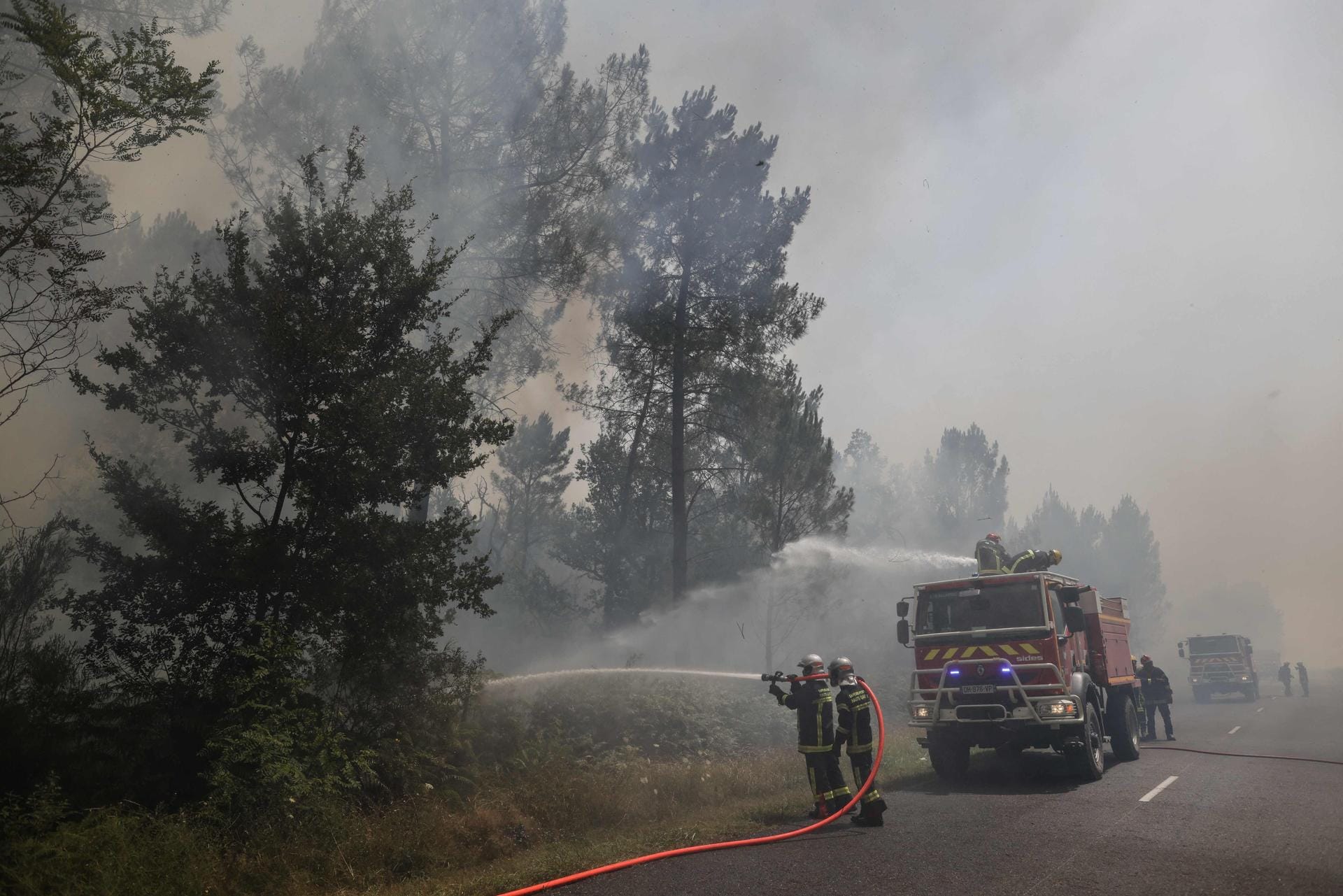 Louchats, Frankreich: Feuerwehrleute stehen bei Löscharbeiten auf einer Straße in der Region Gironde im Südwesten Frankreichs.