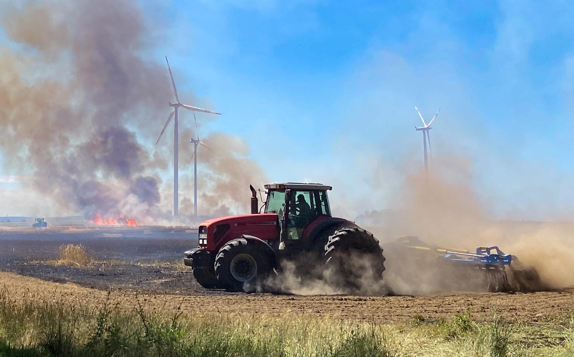 Sieversdorf, Brandenburg: Dunkle Rauchwolken steigen während eines Feuers auf einem Getreidefeld in den Himmel. Bei der Ernte ist aus bisher unbekannter Ursache ein Brand ausgebrochen und hat mehrere Hektar Getreide vernichtet.