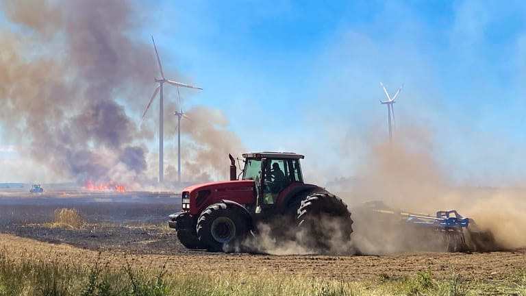 Sieversdorf, Brandenburg: Dunkle Rauchwolken steigen während eines Feuers auf einem Getreidefeld in den Himmel. Bei der Ernte ist aus bisher unbekannter Ursache ein Brand ausgebrochen und hat mehrere Hektar Getreide vernichtet.