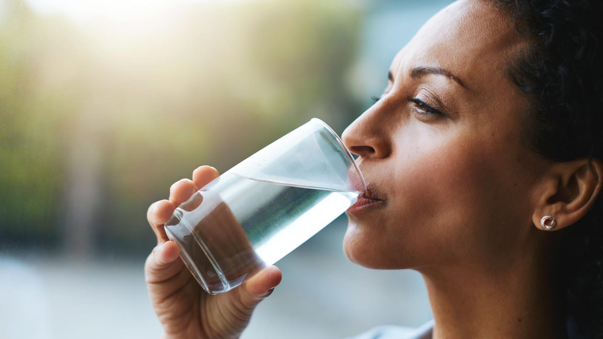 Eine Frau trinkt ein Glas Wasser.