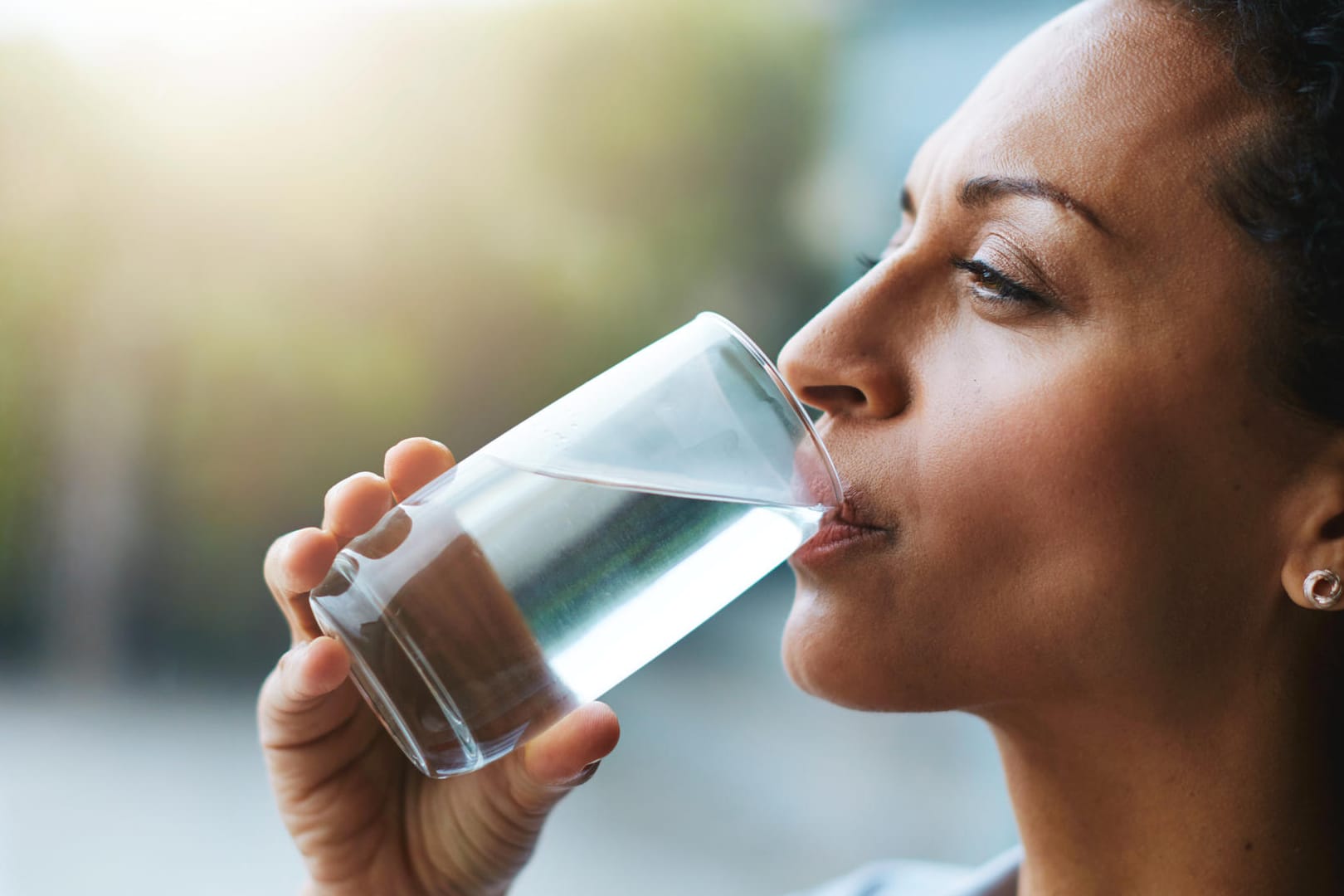 Eine Frau trinkt ein Glas Wasser.