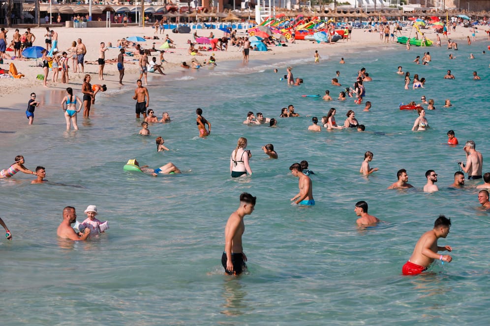 Menschen baden in großer Hitze am Strand bei Magaluf: Abkühlung bringt das derzeit nicht.