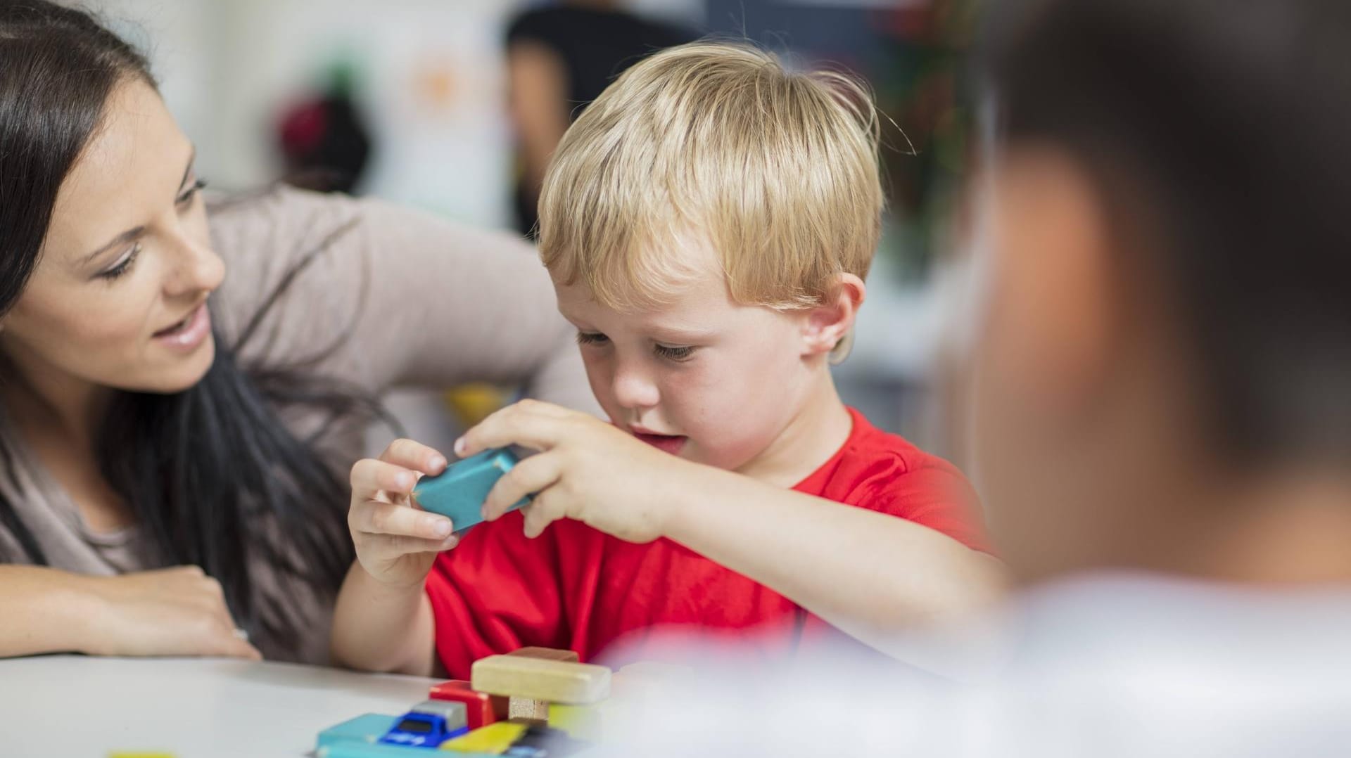 Erzieherin mit Kind im Kindergarten