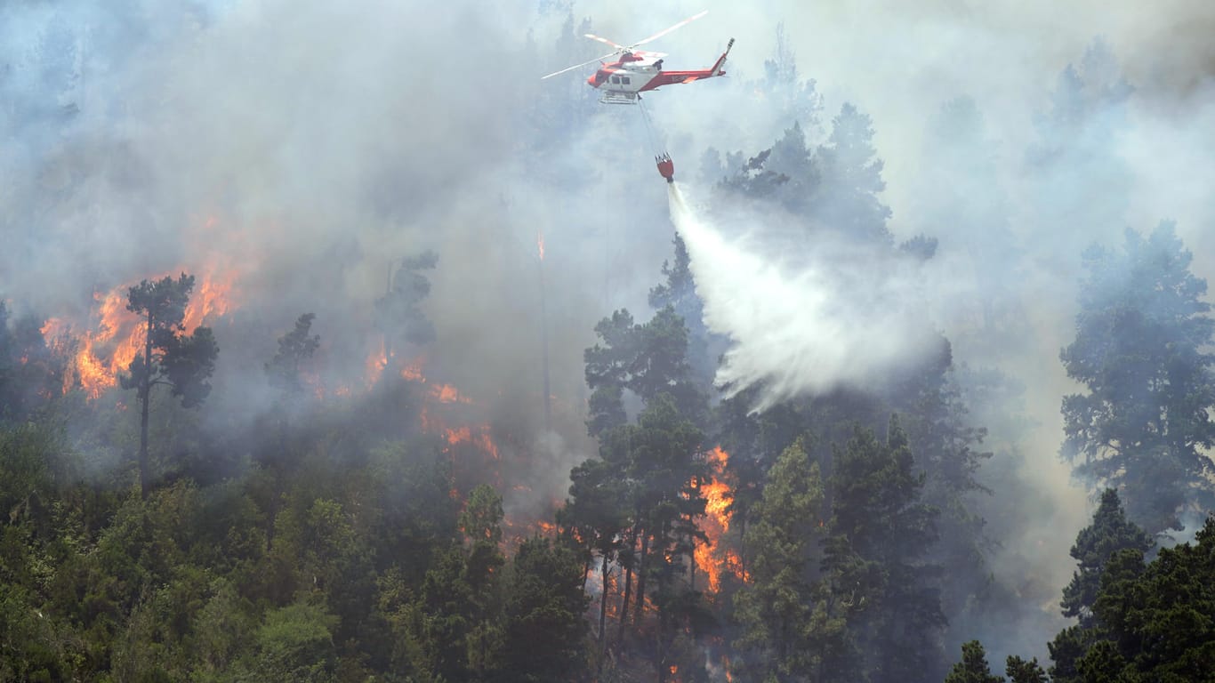 Ein Löschhubschrauber schüttet Wasser auf einen Waldbrand in Spanien: Am Sonntag droht eine neue Hitzewelle, die Feuer anzufachen.